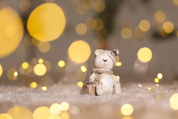 Decorative figurines of a Christmas theme. Statuette of a teddy bear with a scarf, sit next to the...