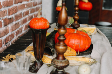 Table setting for Thanksgiving day. Autumn table with pumpkins and candles. fall home decoration for festive dinner 