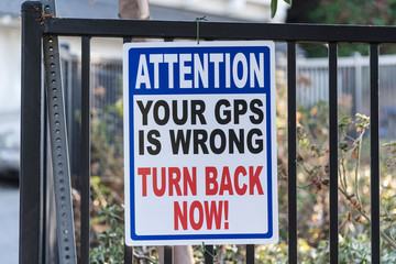 Fototapeta na wymiar Attention your gps is wrong turn back now warning sign. 