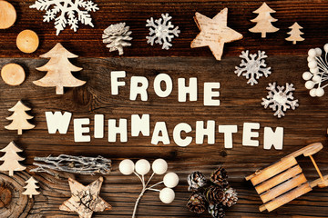 Letters Building The Word Frohe Weihnachten Means Merry Christmas. Wooden Christmas Decoration Like Tree, Sled And Star. Brown Wooden Background