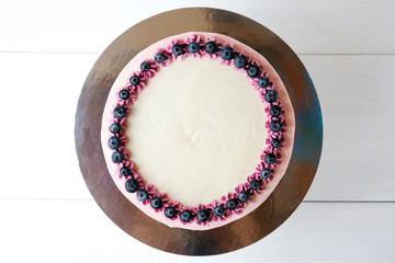 Birthday cake with blueberries and purple gradient cream on white background. Picture for a menu or a confectionery catalog. Top view.
