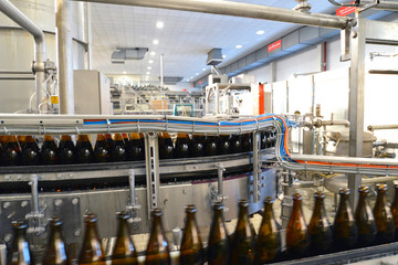 Abfüllen von Bier in Glasflaschen am Fliessband in einer modernen Brauerei // Filling of beer in...