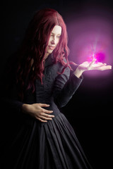 Victorian witch holding a glowing orb. This is a digitally composited image