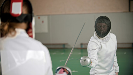 Fencers are attacking each other in the gym