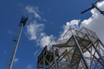 Fototapeta na wymiar Metal structures against the blue sky and white clouds.