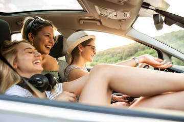 Group of best female friends travel together.They drives a car and making fun.Summer adventure.