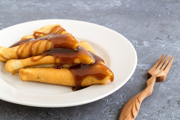 pancakes with syrup on a white plate
