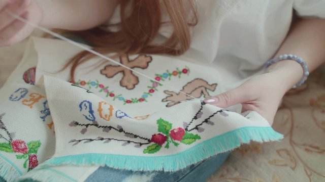 Close view of female hands embroiders the Easter towel. 4K