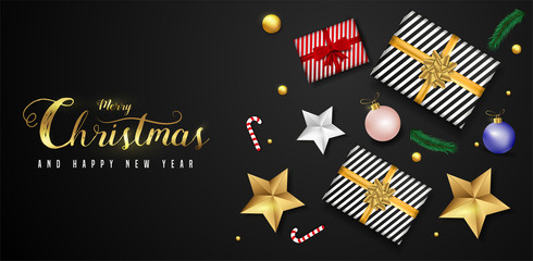Merry Christmas and Happy New Year greeting card design with top view of baubles, gift box, stars and lighting garland decoration on black background.