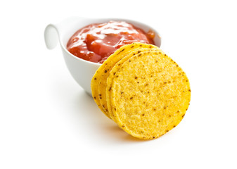 Round corn nacho chips and tomato dip. Yellow tortilla chips and salsa