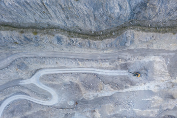 bird's eye view to stone pit quarry with shovel excavator tracks and roads