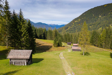 wooden farm huts on mountain meadow at fall autumn in tirol austria