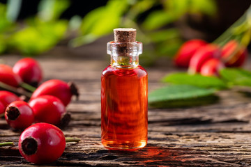 A bottle of rose hip seed oil with fresh berries
