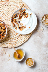 Breakfast bowls with granola, yogurt, coconut chips and honey. Healthy vegan, vegetarian breakfast table
