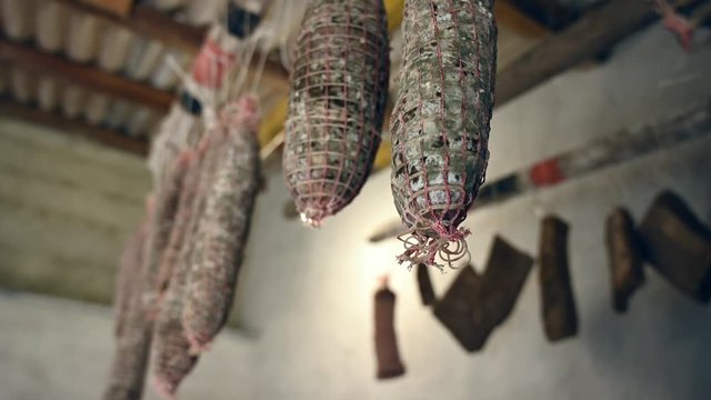 traditional Italian homemade salami salumi cured meat, cold cuts, pancetta , lard, bacon hung to mature ageing dry in the cellar