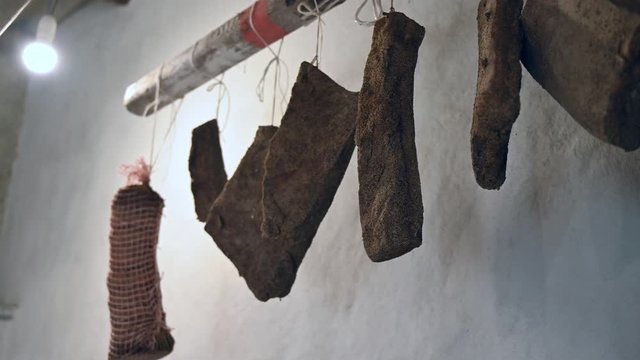traditional Italian homemade salami salumi cured meat, cold cuts, pancetta , lard, bacon hung to mature ageing dry in the cellar