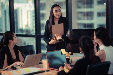 Full concentration at work. Group of young business people working and communicating while sitting at the office desk together with colleagues sitting in the background
