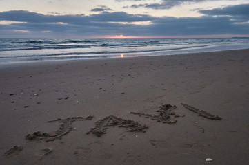 El nobre de JAVI escrito en la arena en la puesta de sol, en la playa de El Palmar, perteneciente a...