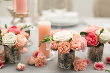 Decor for the holiday table. Natural flowers candle holders in pink colors.