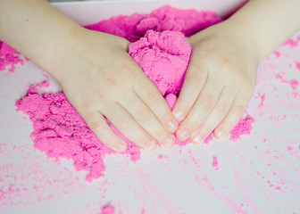 kid play kinetic sand. Pink sand. Magic sand. Close up