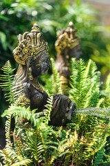 Balinese statuette of a girl with a pot from which water flows. Pool decoration