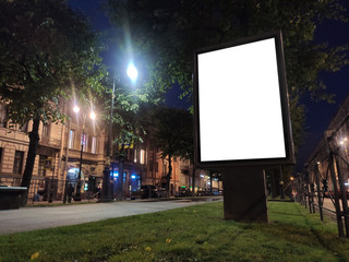 vertical small city billboard advertising city format. mockup at night with white field billboard in the city in the alley glowing advertising box