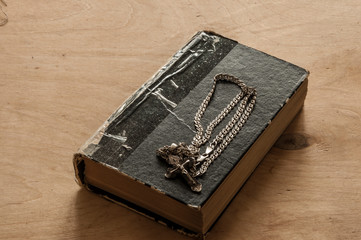 Holy bible with silver cross on wooden background
