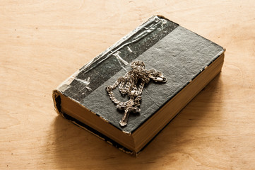 Holy bible with silver cross on wooden background