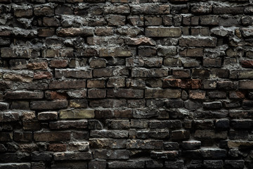 Urban black brick wall texture old masonry background. Gloomy background, black brick wall of dark stone texture