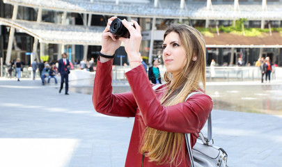 Girl taking pictures with a digital camera outdoor in the city
