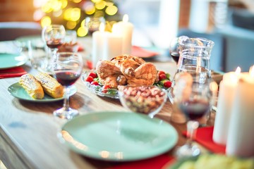 Setting of christmas table on festive holidays, full of traditional food with turky and delicious meals around the tree lights and decoration