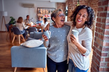 Family and friends dining at home celebrating christmas eve with traditional food and decoration, women talking together happy and casual
