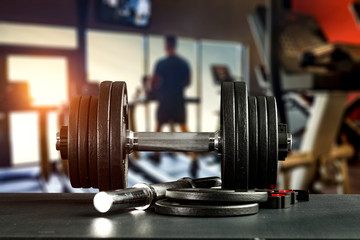 Fototapeta na wymiar Dumbbell, barbell and workout in the gym. Copy space with blurred gym background.