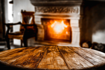 Wooden top with cosy warm home interior with fireplace background.