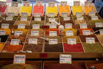 many vessels filled with spices in various colors are offered from an oriental bazaar