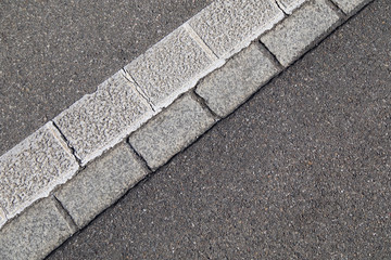 cobblestone edge stone in the middle of a concreted street