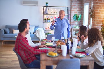 Beautiful family smiling happy and confident. Man speaking a speech celebrating Christmas at home