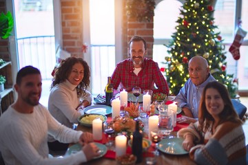 Beautiful family smiling happy and confident. Eating roasted turkey celebrating Christmas at home