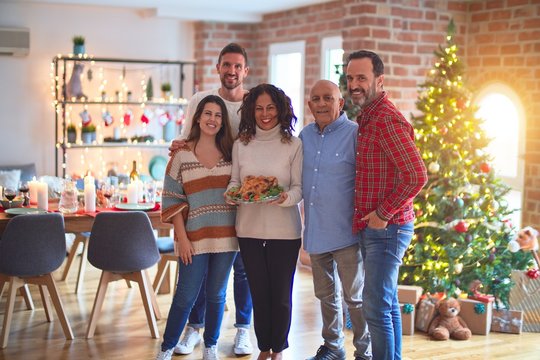 Beautiful family smiling happy and confident. Standing and posing with tree celebrating Christmas at home