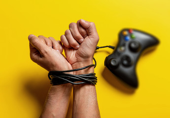 wired hands with joypad, video game addiction