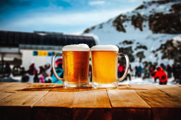 Pint of beer on wooden top with blurred winter background.