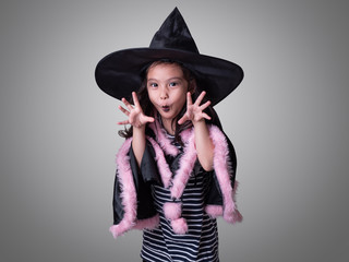 Funny little cute girl cosplay as a witch and makeup on a celebration of Halloween.