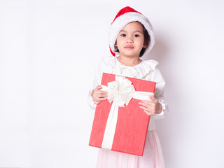 Little cute girl wearing Santa Claus cap and holding red gift box over white background. Use for Christmas concept.
