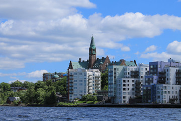 Obraz premium Modern houses in a residential area of Stockholm. White-gray buildings, in the center of an old building with a tower.