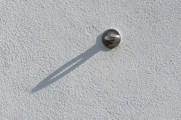 Ringöse aus Metall an Gebäudewand verschraubt zum Einhängen und Spannen von Außenwerbung wie Bannern, Flyern, Plakaten mit einem Schattenwurf in 45 Grad Richtung