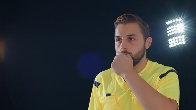 Football Soccer referee on black background whistles and shows VAR Video Assistant Referee, 4k