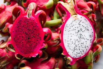 Fresh organic Pitahaya dragon fruit cut in halves and served on the white board. Copy space.