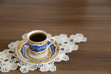 a cup of coffee on the wooden background.