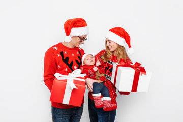 Happy family, mom, dad and little baby with christmas gifts isolated on white background