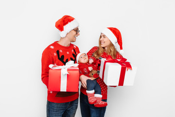 Happy family, mom, dad and little baby with christmas gifts isolated on white background